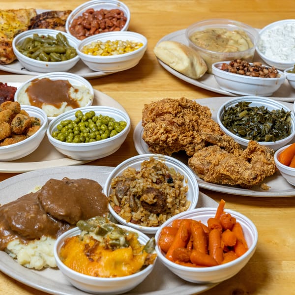 A variety of Southern comfort food dishes, including fried chicken, mashed potatoes, and various vegetables.